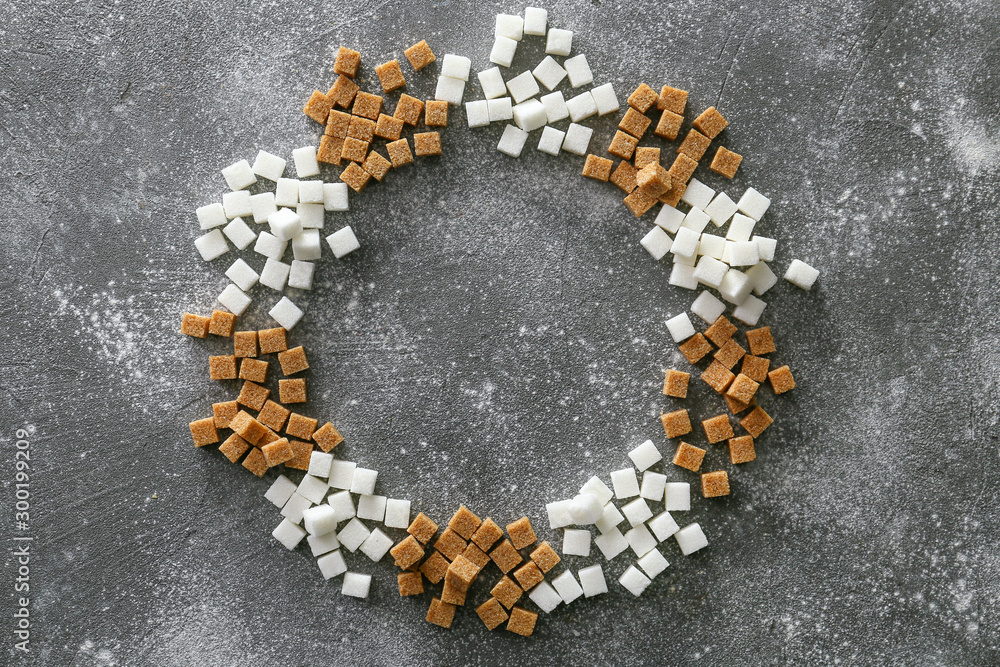 Frame made of different sugar on grey background