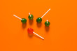 © Pixel-Shot - Orange lollipop among green ones on color background. Concept of uniqueness