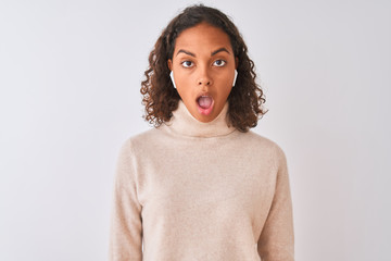 Sticker - Brazilian woman listening to music using wireless earphones over isolated white background scared in shock with a surprise face, afraid and excited with fear expression