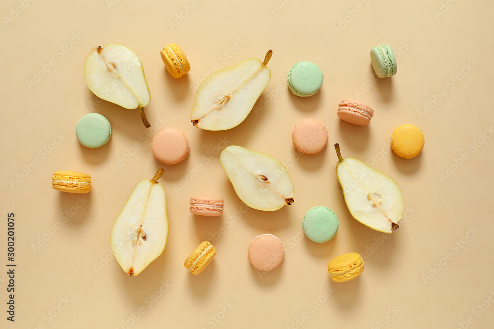 Tasty macarons with pear on color background