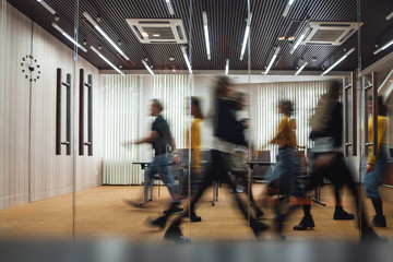 Group of office employees at coworking center. Business people walking at modern open space. Motion blur. Concept