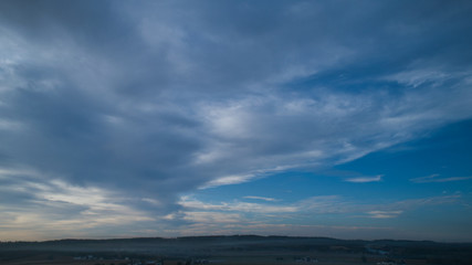 Wall Mural - Aerial View of a Late Afternoon Sun With Partly Cloudy Blue Sky Over Farm Countryside Background