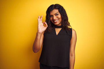 Wall Mural - Transsexual transgender elegant businesswoman standing over isolated yellow background smiling positive doing ok sign with hand and fingers. Successful expression.