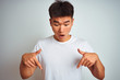 © Krakenimages.com - Young asian chinese man wearing t-shirt standing over isolated white background Pointing down with fingers showing advertisement, surprised face and open mouth