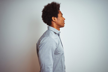 Sticker - Young african american man with afro hair wearing grey shirt over isolated white background looking to side, relax profile pose with natural face with confident smile.