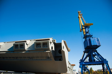 Wall Mural - Loading in port. Floating port crane on blue sky background