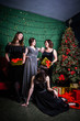 © Uliana - four women in evening gowns posing near corporate Christmas tree