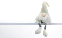 Gnome A Christmas Elf Is Relaxed And Sitting On White Shelf With Hanging Legs