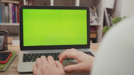 Young hands man use laptop computer with green screen chroma key display internet business office technology work desk connection keyboard pc device close up slow motion