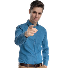 Canvas Print - confident young man in blue shirt smiling and pointing finger