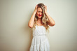 © Krakenimages.com - Young beautiful woman wearing casual dress standing over white isolated background suffering from headache desperate and stressed because pain and migraine. Hands on head.