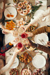 © Seventyfour - Above view background of people raising glasses over festive dinner table while celebrating Christmas with friends and family, copy space