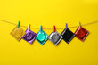 Colorful condoms hanging on clothesline against yellow background. Safe sex concept