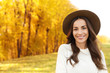 © New Africa - Beautiful happy woman wearing hat in park. Autumn walk