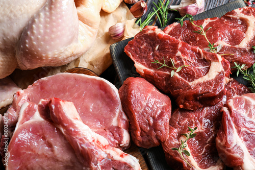 Fotografía Closeup view of fresh raw meat and herbs on table