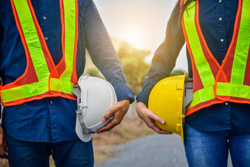 Male and Female Engineer holding hardhat safety