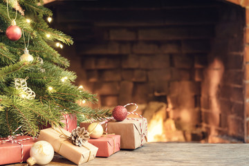 Gifts under the Christmas tree in the room with a fireplace on Christmas eve