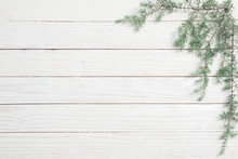 Juniper Branches On A White Wooden Background. Christmas And New Year Background