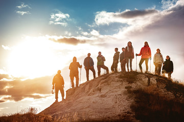 Big group of hikers against sunset