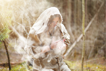 Wall Mural - A man in a cassock spends a ritual in a dark forest