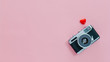Leinwandbild Motiv Top view of vintage old camera and little red heart on pink pastel background with empty space for text.Travel in holiday vacation with retro banner concept.