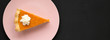 Homemade Thanksgiving pumpkin pie on a pink plate on a black background, top view. Overhead, from above, flat lay. Copy space.