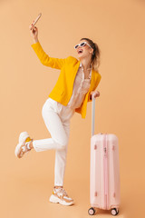 Canvas Print - Photo of laughing woman taking selfie on cellphone while standing