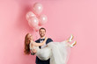 Attractive redhaired woman wearing white wedding dress sit on man's hands. Cheerful smiling couple happy together, marriage proposal