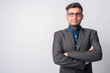 © Ranta Images - Portrait of young Persian businessman in suit with arms crossed