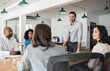 © mavoimages - Smiling businessman meeting with his diverse team in an office
