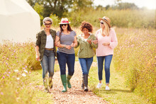Group Of Mature Female Friends Walking Along Path Through Yurt Campsite