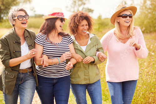 Fotografía Group Of Mature Female Friends Walking Along Path Through Yurt Campsite