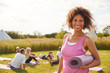 © Monkey Business - Portrait Of Mature Woman On Outdoor Yoga Retreat With Friends And Campsite In Background