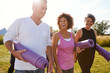 © Monkey Business - Group Of Mature Men And Women With Exercise Mats At End Of Outdoor Yoga Class