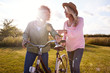 © Monkey Business - Two Mature Female Friends Walking Along Path With Bike Through Yurt Campsite