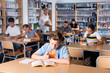 © JackF - Schoolboy preparing for lesson with books in school library indoor