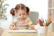 © Oksana Kuzmina - Cute little child girl writing with pencils in day care center