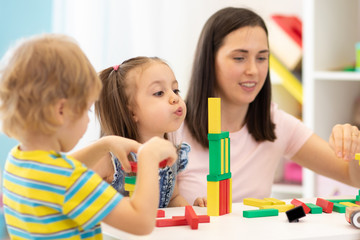 Wall Mural - Kids with teacher in kindergarten or daycare