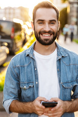 smiling handsome young man using mobile phone