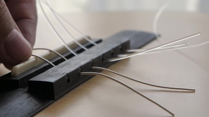 Wall Mural - Close-up hands of man replacing acoustic classic guitar using nylon and silver string for jazz and easy listening music style select focus shallow depth of field