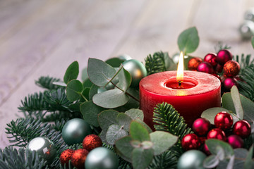 Wall Mural - christmas candle with fir branches and eucalyptus leaves on rustic wooden background - advent time