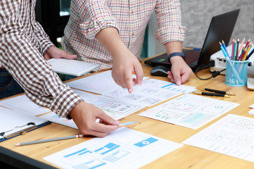 Graphic designers work together with UX UI designer planning application template layout framework for mobile phone computer mobile