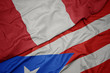 waving colorful flag of puerto rico and national flag of peru.