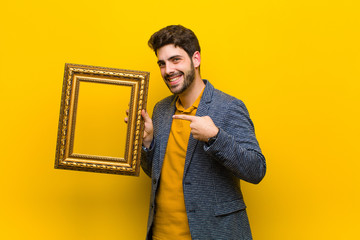 young handsome man with a baroque frame against orange backgroun