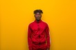 © Asier - Young african sporty man standing against a yellow background