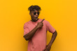 © Asier - Young casual black man wearing sunglasses pointing to the side