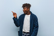 © Asier - Young african black man wearing pajama pointing to the side