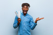 © Asier - Young rasta black man holding an air tickets impressed holding copy space on palm.