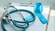 Blue awareness ribbon for prostate cancer, men health and diabetes in November with light blue bow color on medical doctor record, male patient healthcare concept