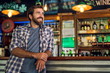 © PhotoAlto - Smiling thoughtful man leaning against bar counter